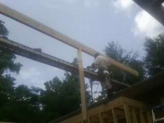 Carpenter setting a ridge beam over a new addition frame — Ice Dam Removal by Roofing Brothers in Novelty