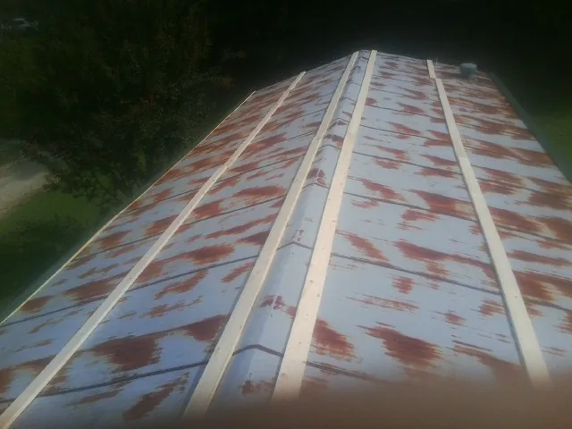 Rusted metal roof panels with new wood purlins before replacement — Storm Damage Roof Repair in Novelty by Roofing Brothers