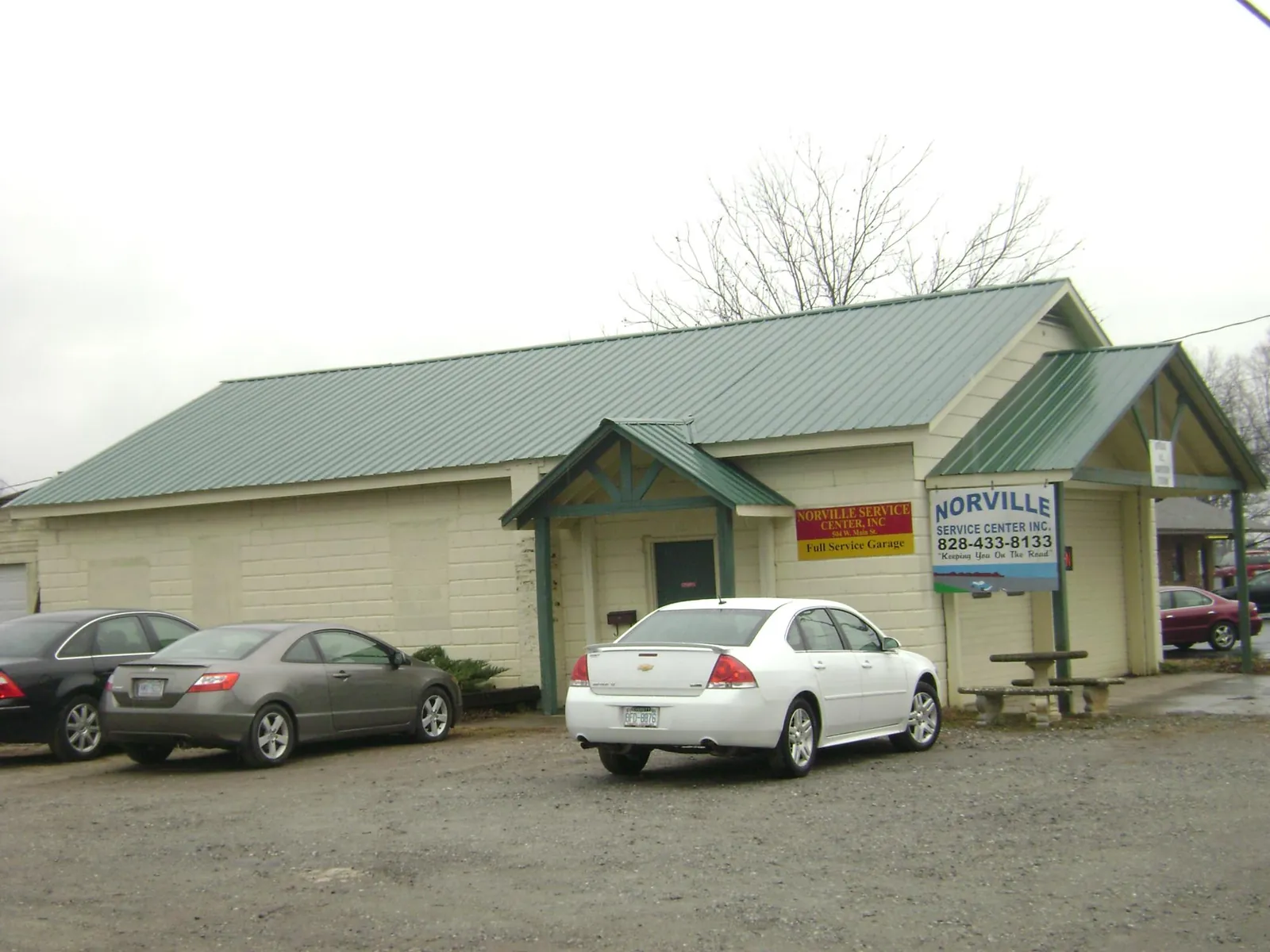 Green metal roof on a service garage with a covered entry in Novelty